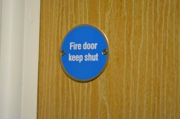 A wooden fire door being kept shut and ready to be inspected.