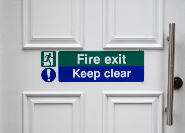 Fire-resistant door marked with fire exit and keep clear signs which is an example of what is classified as passive fire protection rather than active fire protection.