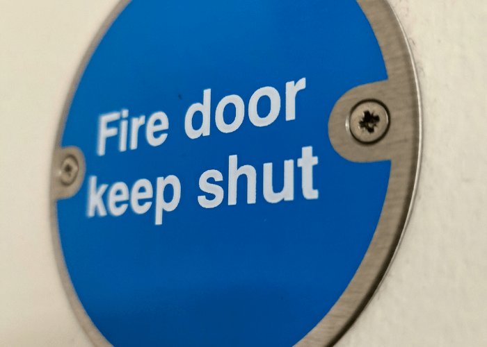 A closeup of a blue fire door sign on a door. 